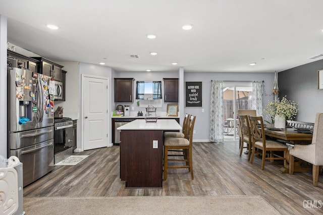5803 Vespucci Ave, Bakersfield, CA 93313 - kitchen with stainless steel appliances, dark brown cabinets, wood finished floors, a breakfast bar, and recessed lighting