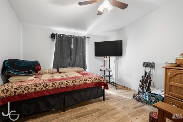 bedroom with wood tiled floor, vaulted ceiling, baseboards, and ceiling fan