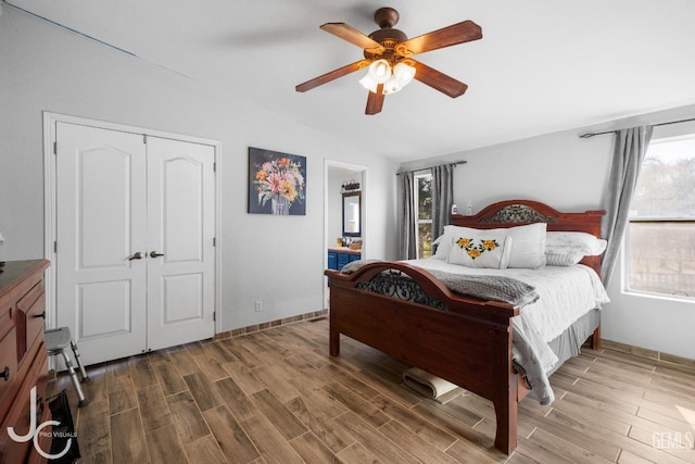 bedroom with vaulted ceiling, ceiling fan, a closet, and wood tiled floor