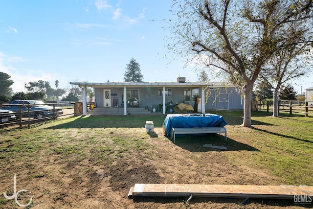 back of house with a fenced backyard and a lawn