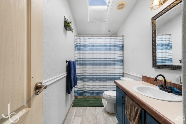 bathroom featuring visible vents, toilet, wood finished floors, curtained shower, and vanity