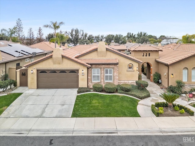 mediterranean / spanish-style home featuring a garage and a front lawn