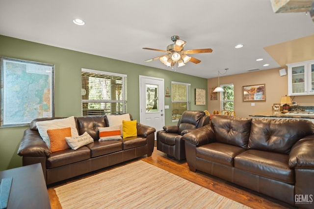 living room featuring ceiling fan and light hardwood / wood-style flooring