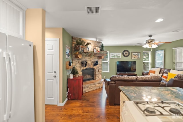 kitchen with a fireplace, dark hardwood / wood-style flooring, white fridge, and ceiling fan