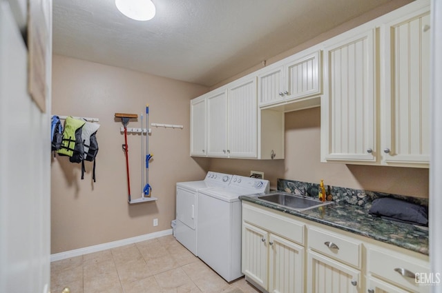 washroom with cabinets, light tile patterned floors, washer and dryer, and sink