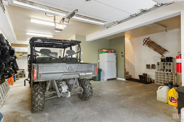 garage with white refrigerator and a garage door opener