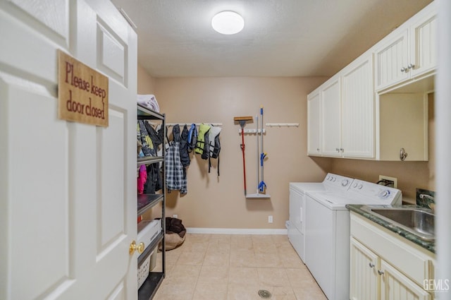 laundry area featuring cabinets, separate washer and dryer, sink, and light tile patterned floors