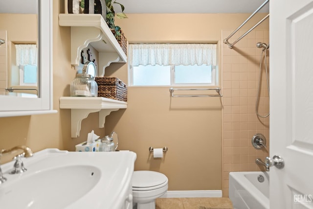 full bathroom with tile patterned flooring, tiled shower / bath combo, toilet, and sink