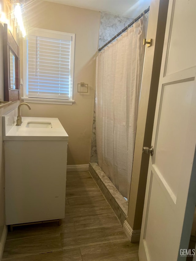1312 Townsley Ave, Bakersfield, CA 93304 - bathroom with wood finished floors, vanity, curtained shower, and baseboards