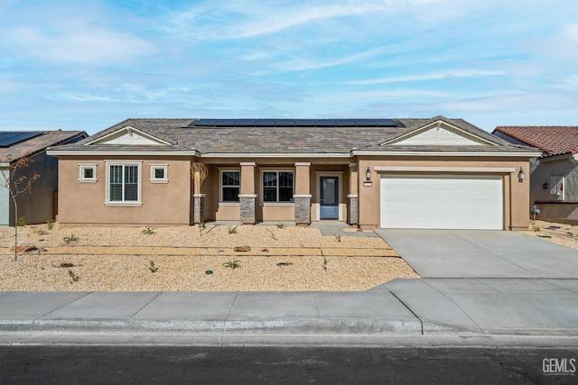 single story home featuring stucco siding, roof mounted solar panels, concrete driveway, and an attached garage