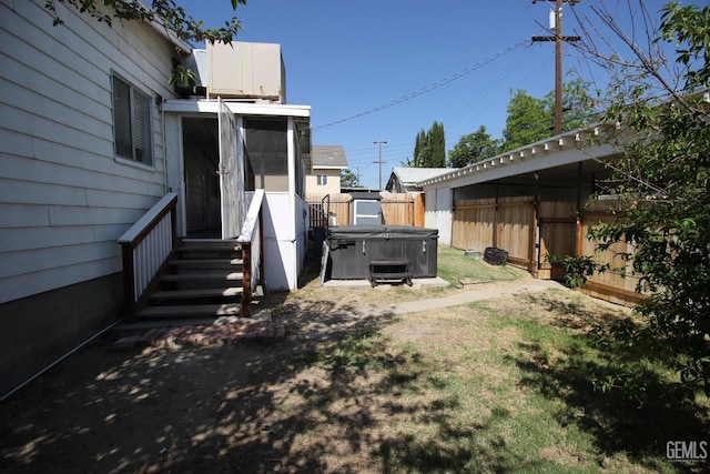 view of yard with fence and a hot tub