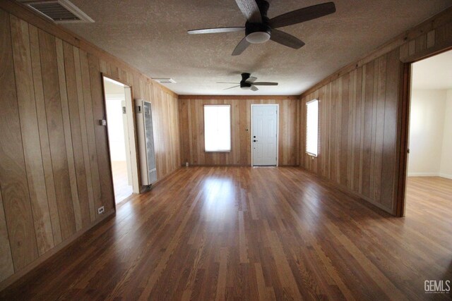 unfurnished room featuring visible vents, a ceiling fan, a textured ceiling, and wood finished floors
