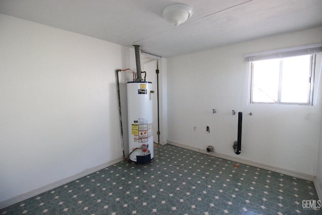 laundry room with carpet floors, baseboards, gas water heater, and laundry area