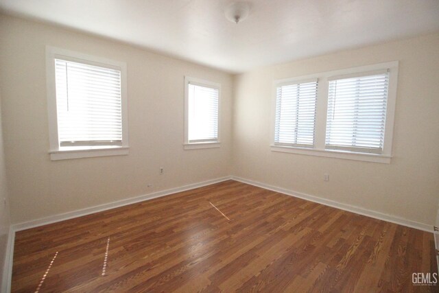 unfurnished room featuring baseboards and wood finished floors