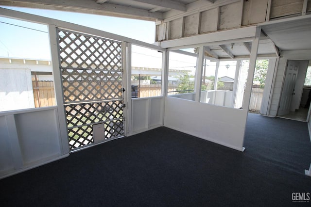 unfurnished sunroom featuring beamed ceiling