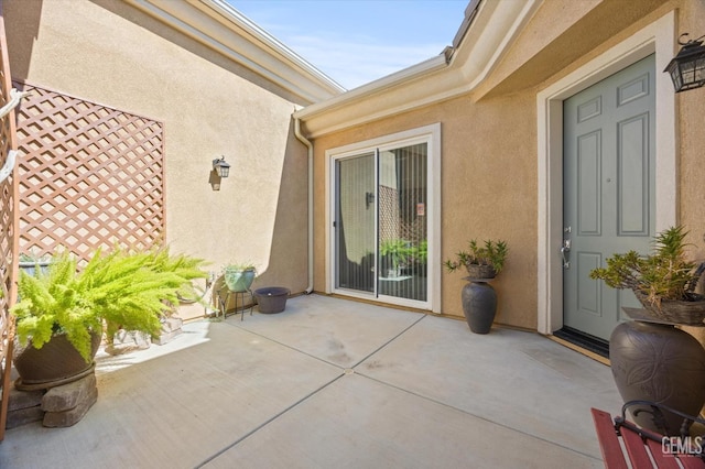 doorway to property with a patio area and stucco siding