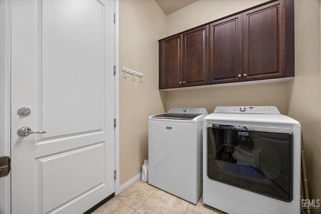 washroom with cabinet space, baseboards, light tile patterned flooring, and independent washer and dryer