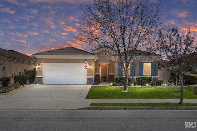 view of front of home featuring driveway, a garage, a lawn, and stucco siding