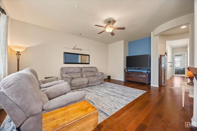 living area with a ceiling fan, dark wood-style flooring, visible vents, and baseboards