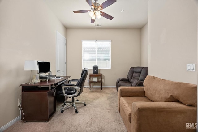 office space featuring light carpet, a ceiling fan, visible vents, and baseboards