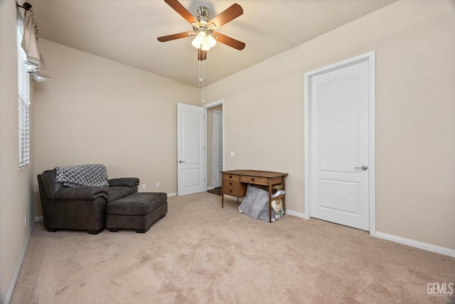 living area with a ceiling fan, light colored carpet, and baseboards