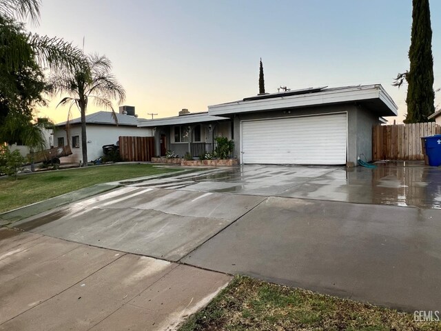 1208 W Point Dr, Bakersfield, CA 93305 - ranch-style home with an attached garage, roof mounted solar panels, concrete driveway, and stucco siding