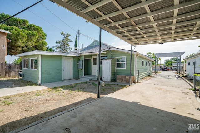 view of front of property featuring fence and a carport