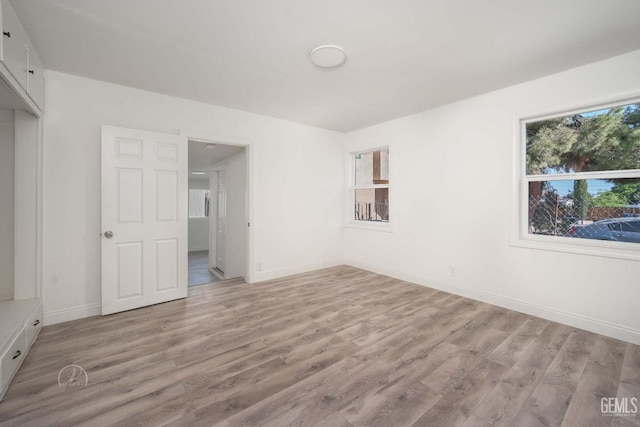 unfurnished bedroom featuring light wood-style floors and baseboards