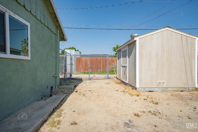 view of yard featuring an outdoor structure, fence, and a storage unit