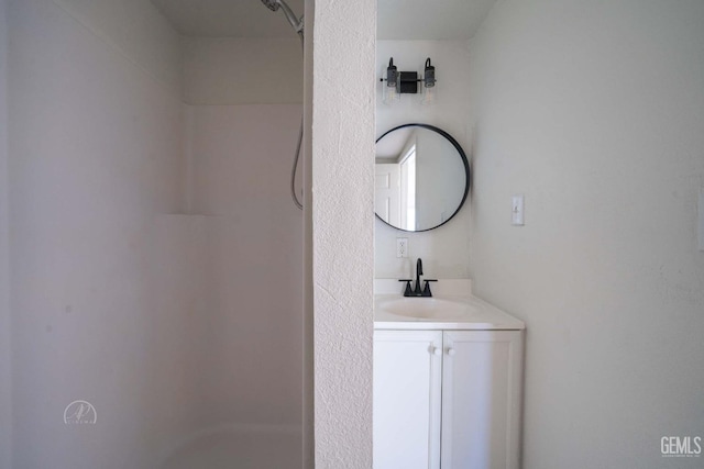 bathroom with walk in shower and vanity