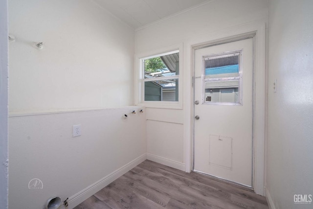 doorway featuring baseboards and wood finished floors