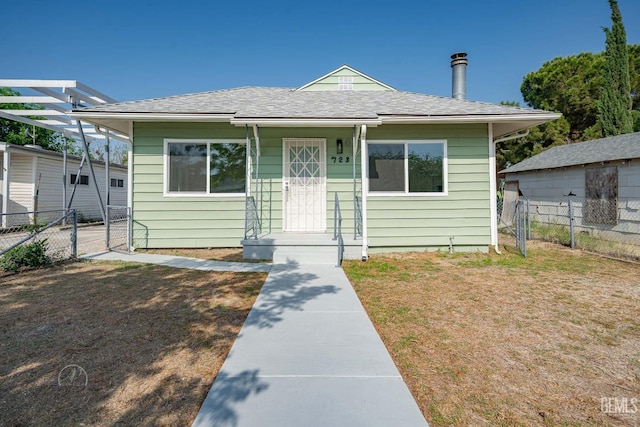 bungalow-style house featuring fence, a shingled roof, and a front lawn