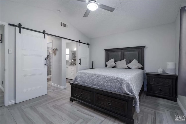 6513 Derby Dr, Bakersfield, CA 93306 - bedroom with a barn door, vaulted ceiling, a textured ceiling, a ceiling fan, and connected bathroom