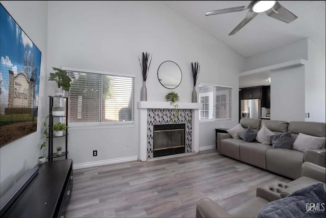 6513 Derby Dr, Bakersfield, CA 93306 - living area featuring a ceiling fan, high vaulted ceiling, wood finished floors, plenty of natural light, and a tiled fireplace
