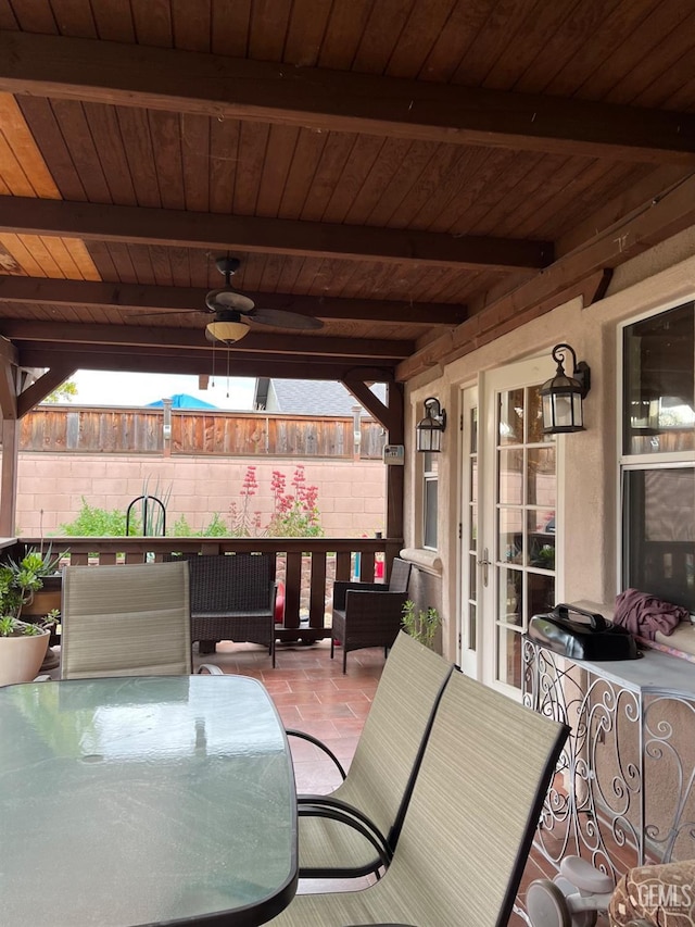 view of patio with outdoor dining space, a ceiling fan, and fence