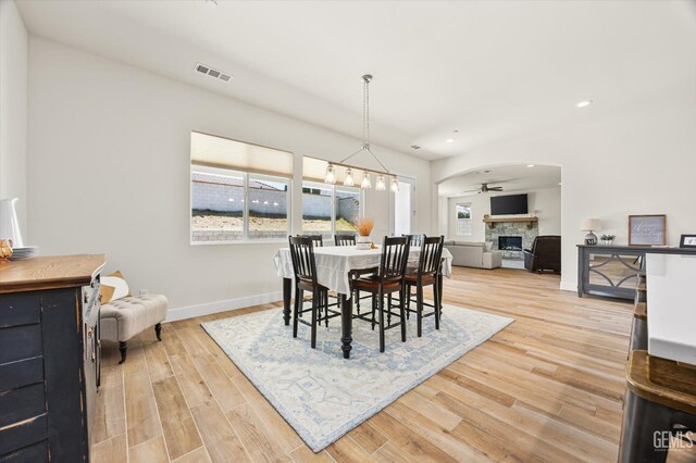 506 Rosehaven Ln, Tehachapi, CA 93561 - dining room featuring arched walkways, light wood-style floors, visible vents, and a healthy amount of sunlight