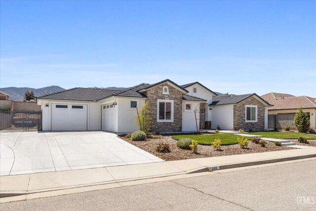 506 Rosehaven Ln, Tehachapi, CA 93561 - view of front of house featuring stucco siding, fence, stone siding, an attached garage, and driveway
