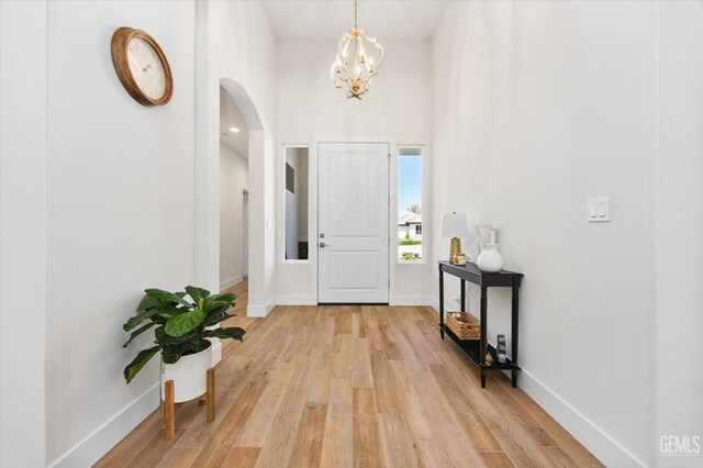 506 Rosehaven Ln, Tehachapi, CA 93561 - foyer featuring light wood-style flooring, arched walkways, a chandelier, and baseboards