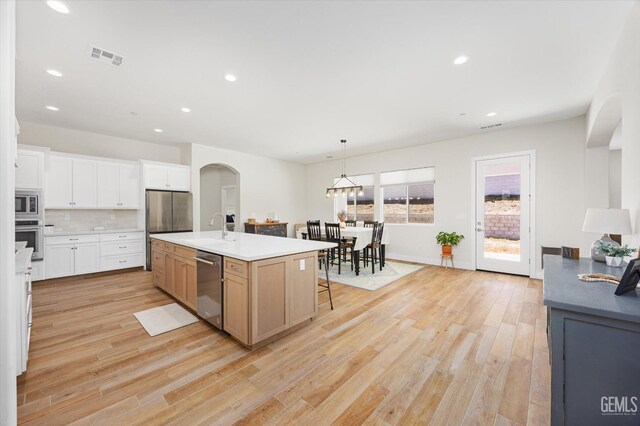 506 Rosehaven Ln, Tehachapi, CA 93561 - kitchen featuring a sink, tasteful backsplash, appliances with stainless steel finishes, and light wood-style floors