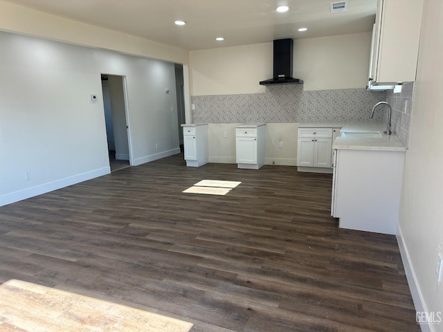 kitchen with white cabinetry, tasteful backsplash, dark wood-type flooring, wall chimney exhaust hood, and sink