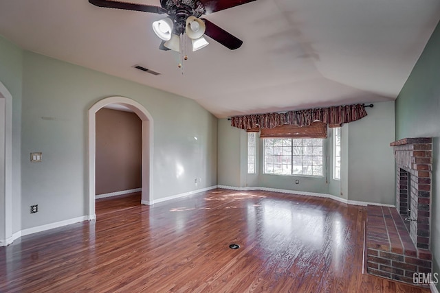 unfurnished living room with lofted ceiling, hardwood / wood-style floors, a brick fireplace, and ceiling fan