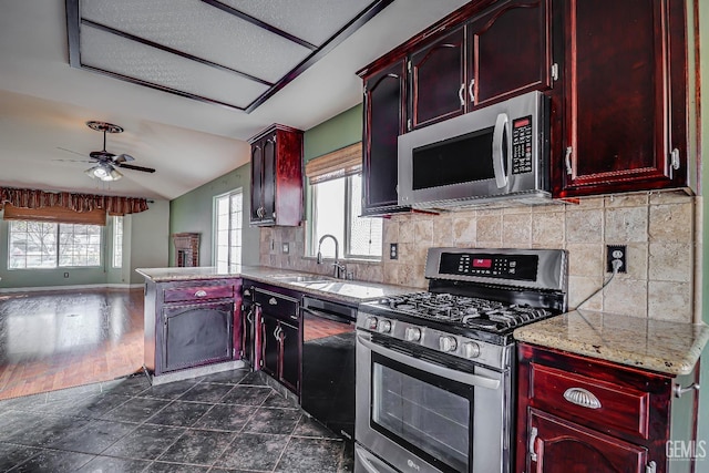 kitchen featuring sink, appliances with stainless steel finishes, ceiling fan, light stone countertops, and decorative backsplash