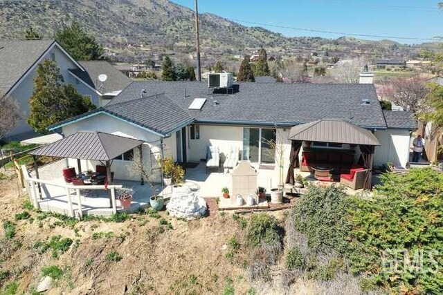 22824 Mariposa Rd, Tehachapi, CA 93561 - rear view of property featuring central air condition unit, a gazebo, stucco siding, a mountain view, and a patio area