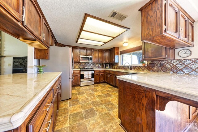 22824 Mariposa Rd, Tehachapi, CA 93561 - kitchen with tasteful backsplash, stainless steel appliances, a sink, visible vents, and a peninsula