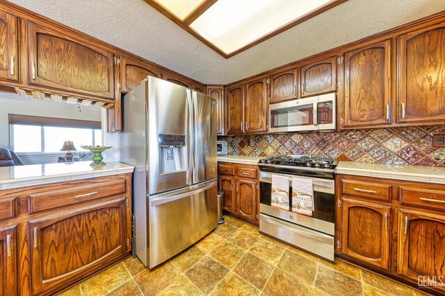 22824 Mariposa Rd, Tehachapi, CA 93561 - kitchen with backsplash, appliances with stainless steel finishes, and brown cabinets