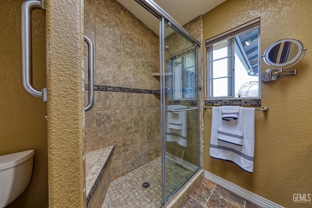 22824 Mariposa Rd, Tehachapi, CA 93561 - bathroom featuring a textured wall, toilet, a shower stall, and stone tile floors