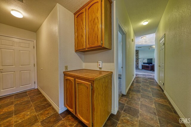 22824 Mariposa Rd, Tehachapi, CA 93561 - hallway with a textured wall, stone finish flooring, baseboards, and a textured ceiling