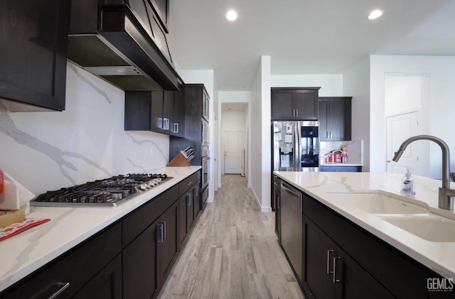 15920 Waterford St, Bakersfield, CA 93314 - kitchen featuring range hood, stainless steel appliances, light wood finished floors, light stone countertops, and recessed lighting