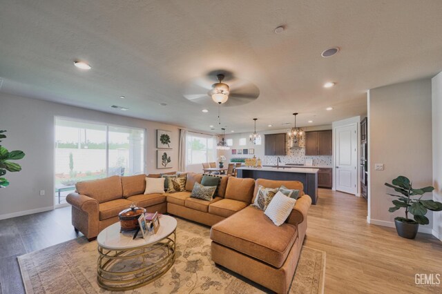 7518 Garrison Ave, Bakersfield, CA 93311 - living area featuring recessed lighting, a ceiling fan, light wood-style floors, a chandelier, and baseboards
