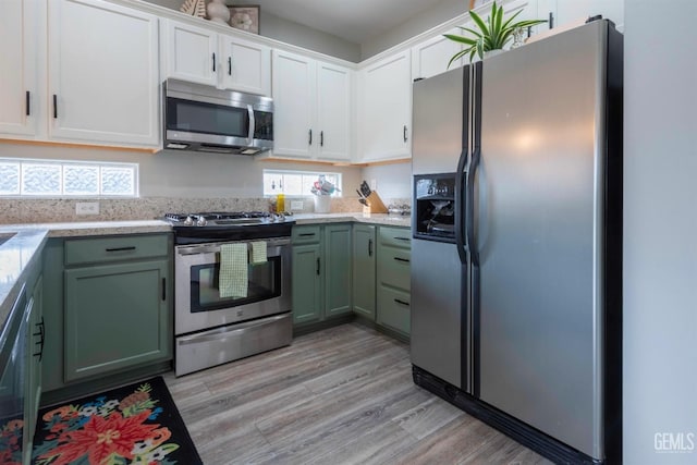 kitchen featuring stainless steel appliances, green cabinets, and white cabinets